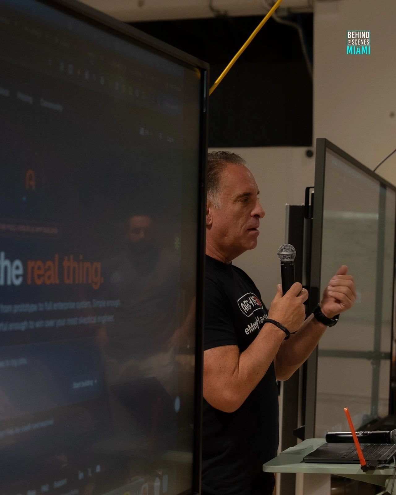 The real thing, live: a builder takes the microphone at the Miami AI Summit hackathon.