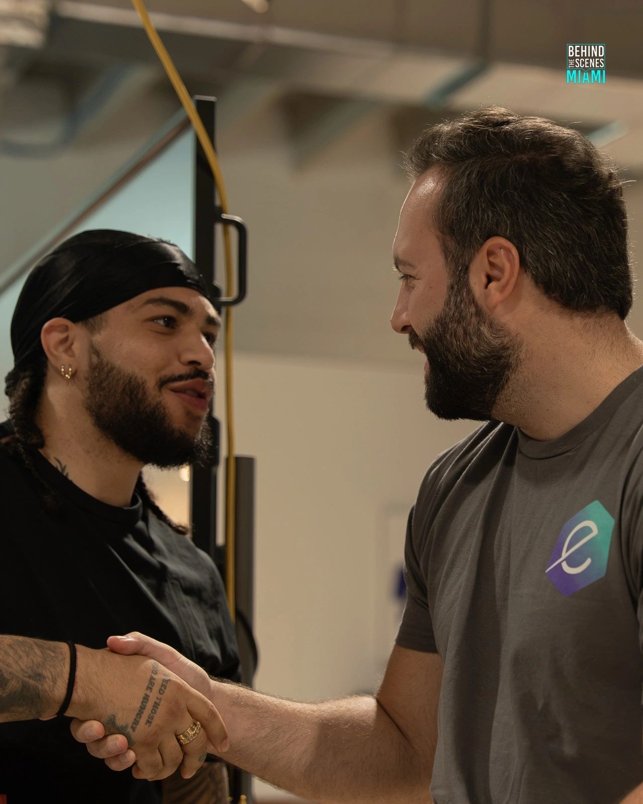 A handshake seals it: two builders meet at the Miami AI Summit hackathon.